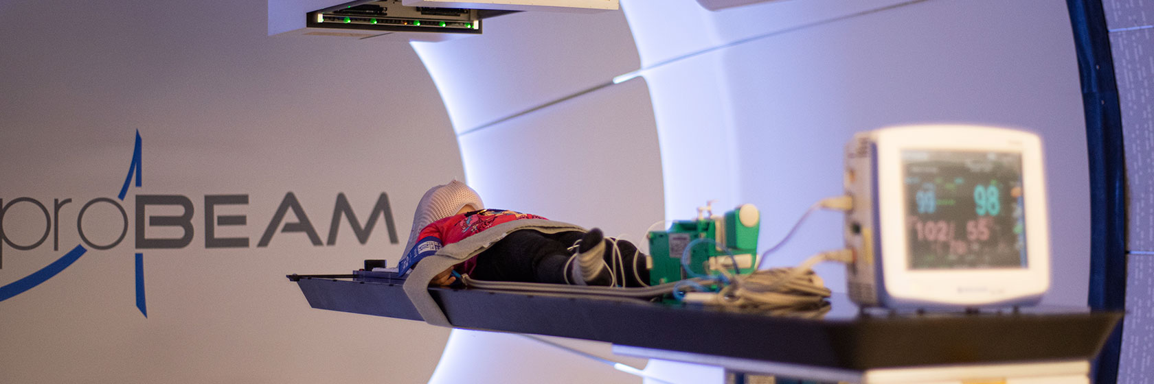 A child is undergoing proton therapy at the MIBS Proton Therapy Center